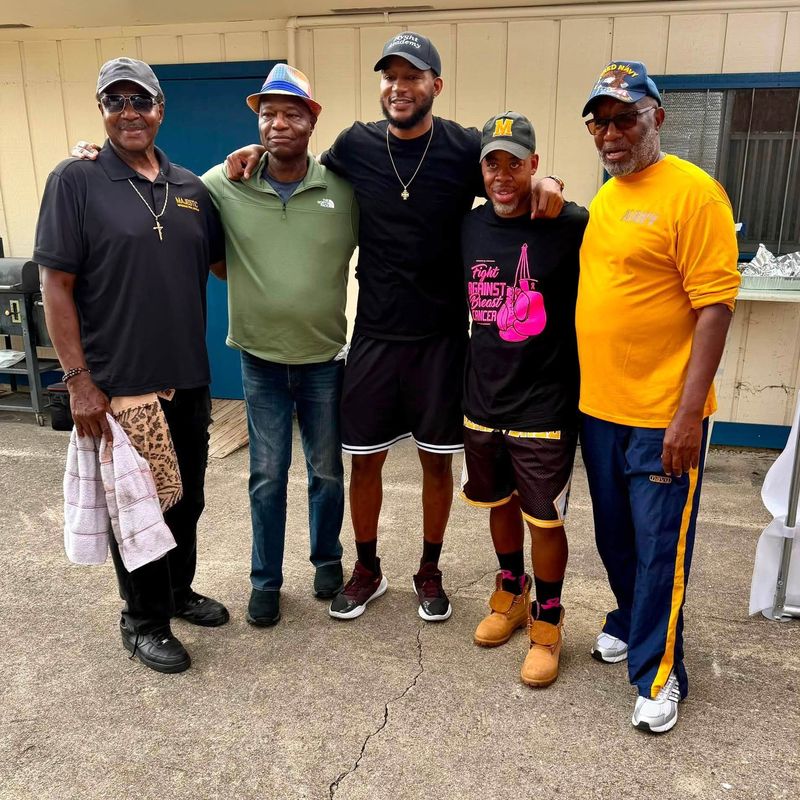 Five men standing together outside the pavilion