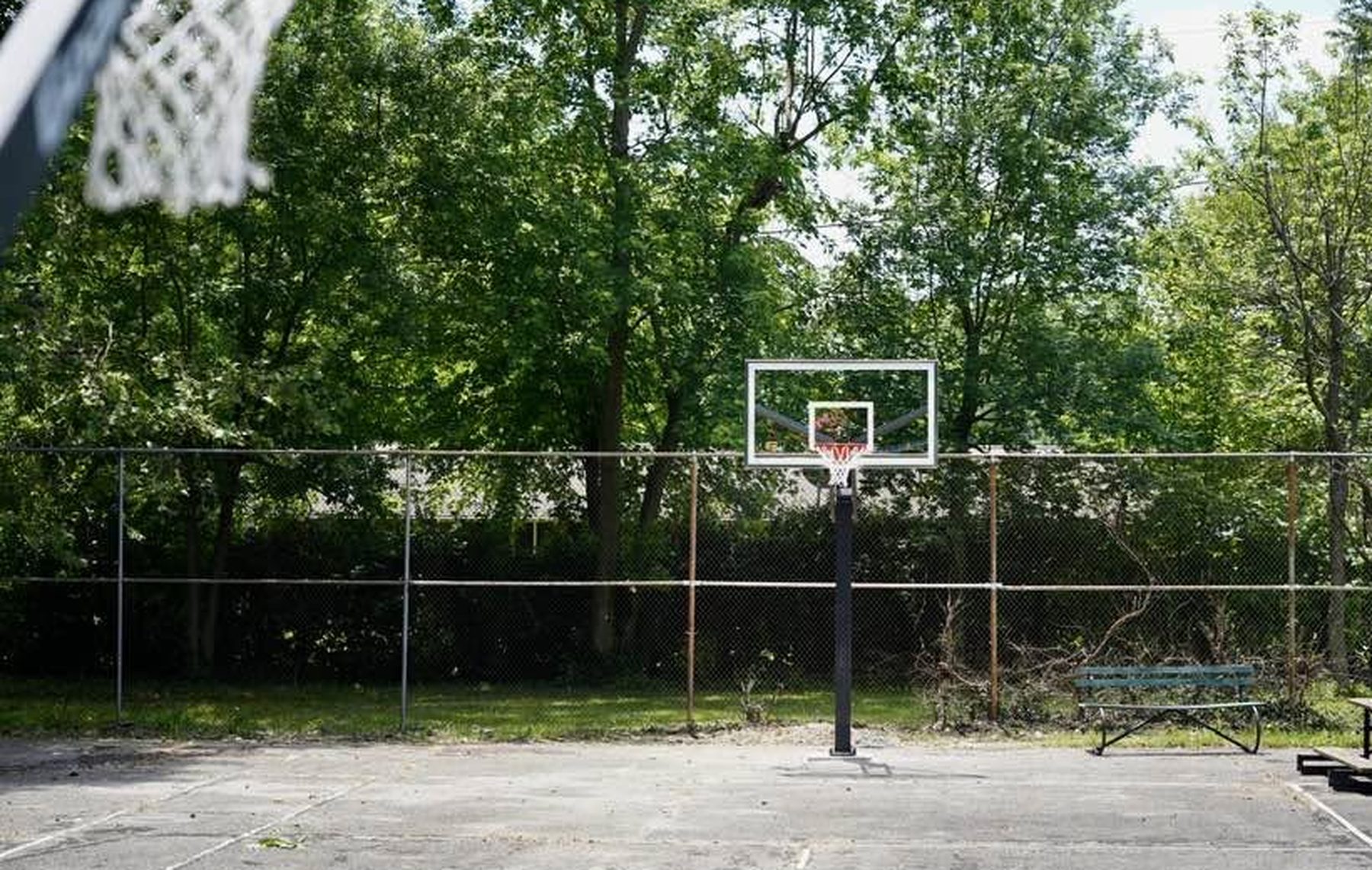 A basketball hoop on the church's current court, seen from under the opposite rim